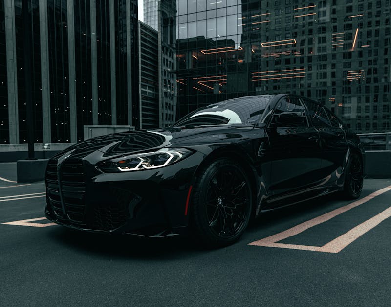 A stylish black sports car parked in a downtown Chicago parking lot.