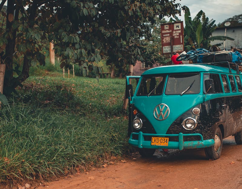 A classic Volkswagen van parked on a scenic rural road with lush greenery.